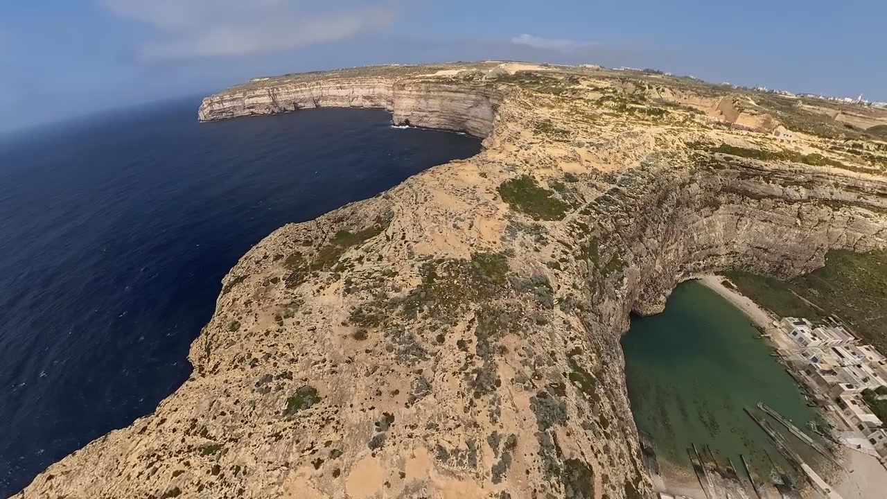 Ampia ripresa video panoramica dall'alto, da un drone che sorvola la formazione rocciosa che separa il mare e la piccola baia chiamata Inland Sea a Gozo, un popolare luogo di balneazione sull'isola