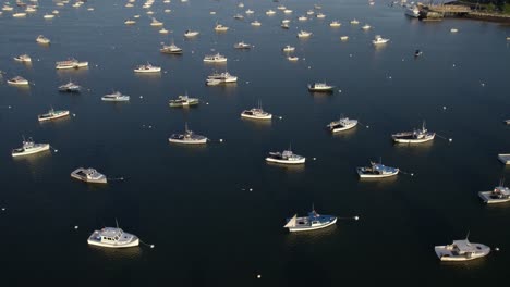 Vista-Aérea-Sobre-Barcos-Anclados-En-La-Costa-De-Plymouth,-Puesta-De-Sol-En-Massachusetts,-Ee