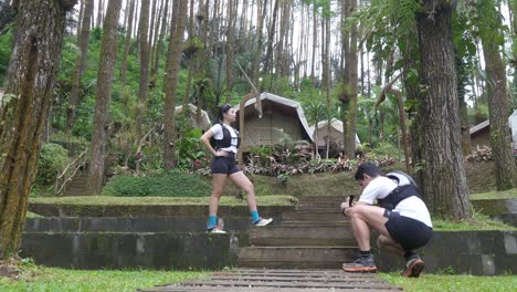 asian couple taking photos during outdoor adventure in forest