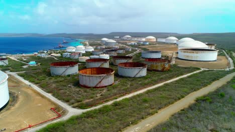 Revelación-Aérea-4k-De-Tanques-Y-Silos-De-Almacenamiento-De-Petróleo-Junto-Al-Océano,-Terminal-Petrolera-Bullenbaai-En-Curacao