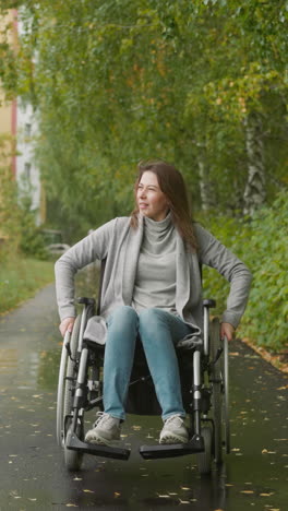 una mujer con lesión en la médula espinal descansa disfrutando de la naturaleza en un paseo cerca del sanatorio. una joven sonríe satisfecha inhalando aire fresco. rehabilitación después de un accidente