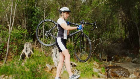 ciclista de alto nivel llevando una bicicleta en el campo 4k