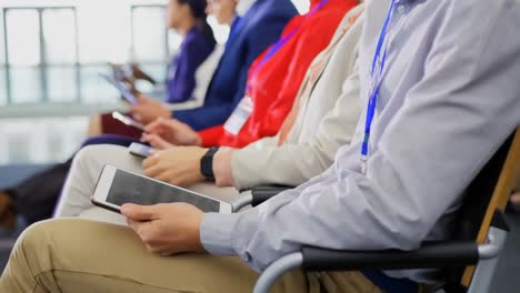 animación de iconos de redes sociales sobre la sección media del hombre usando tableta digital en una conferencia de negocios.