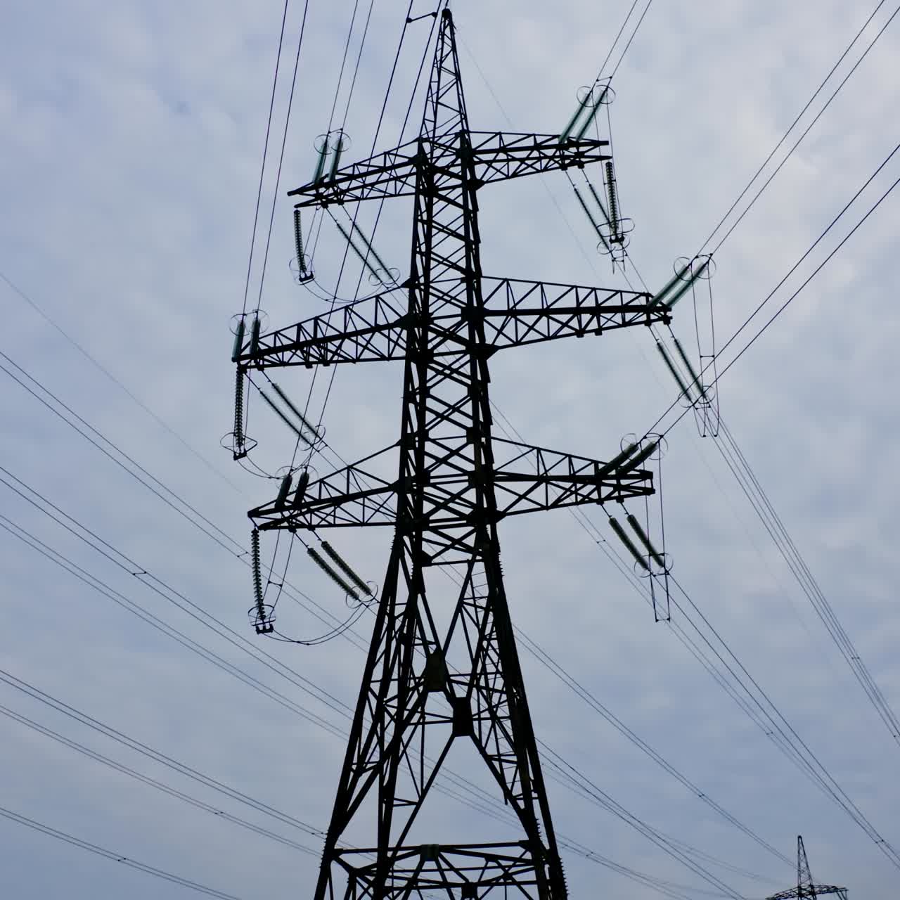 Energy distribution network. Electricity pylons against orange and yellow sunset. Selective focus