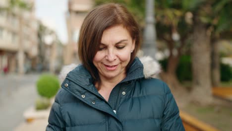 middle age woman listening to music and dancing at street