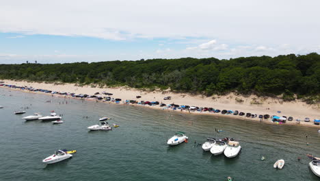 Geparkte-Fahrzeuge-Am-Strand-Von-Nickel-Beach-Mit-Segelbooten-Im-Wasser-In-Port-Colborne,-Kanada