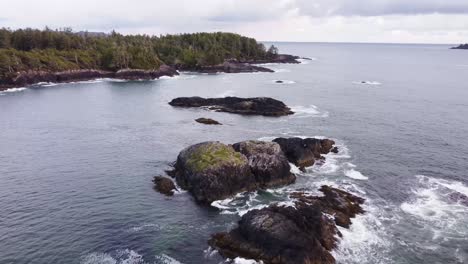 a drone video tilting down towards some large rocks above the ocean