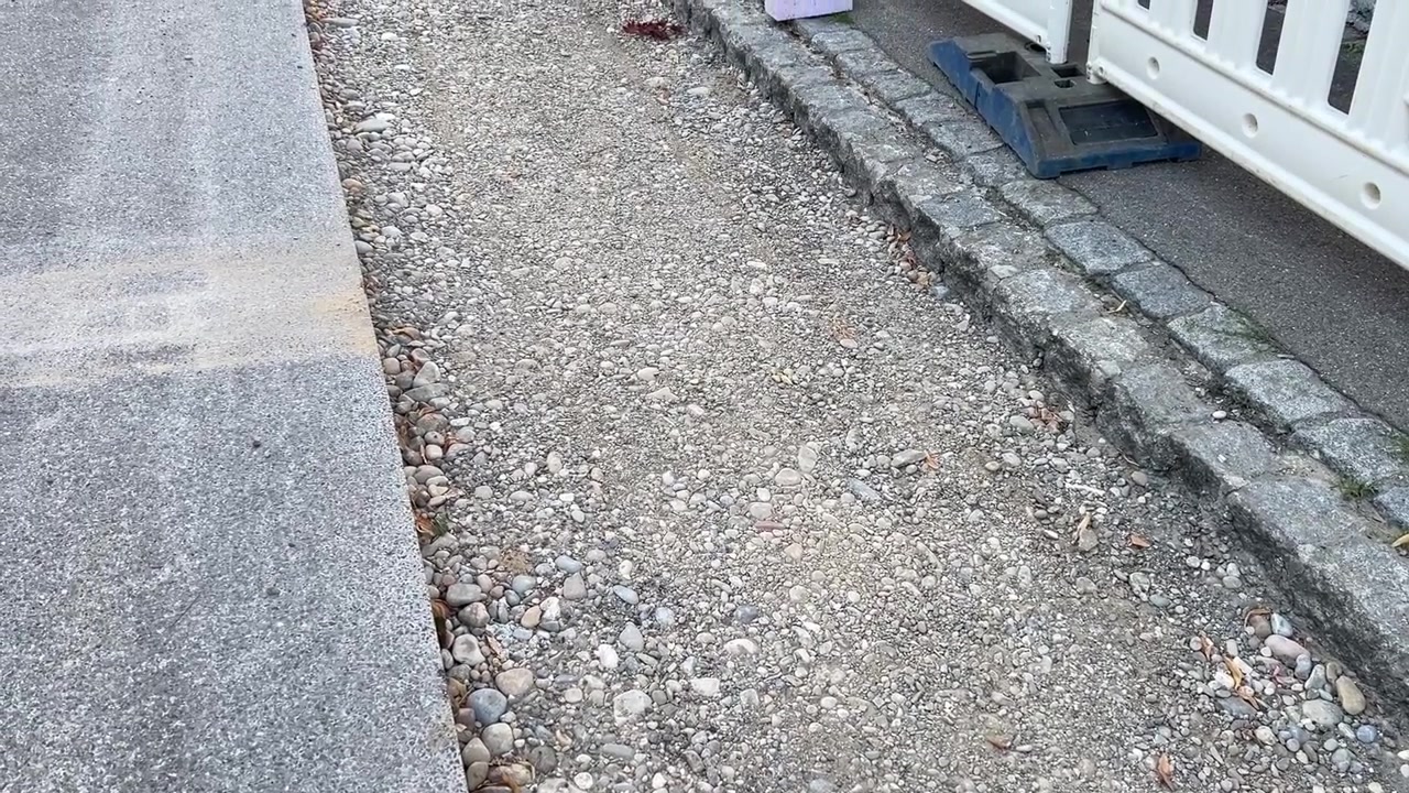 Slightly high angle into a backfilled district heating trench, filled with gravel while the sand and asphalt layers are still missing. A stage of utility groundwork and street reinstatement in Germany