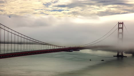 fog over the san francisco bay with boats under the golden gate bridge - time lapse
