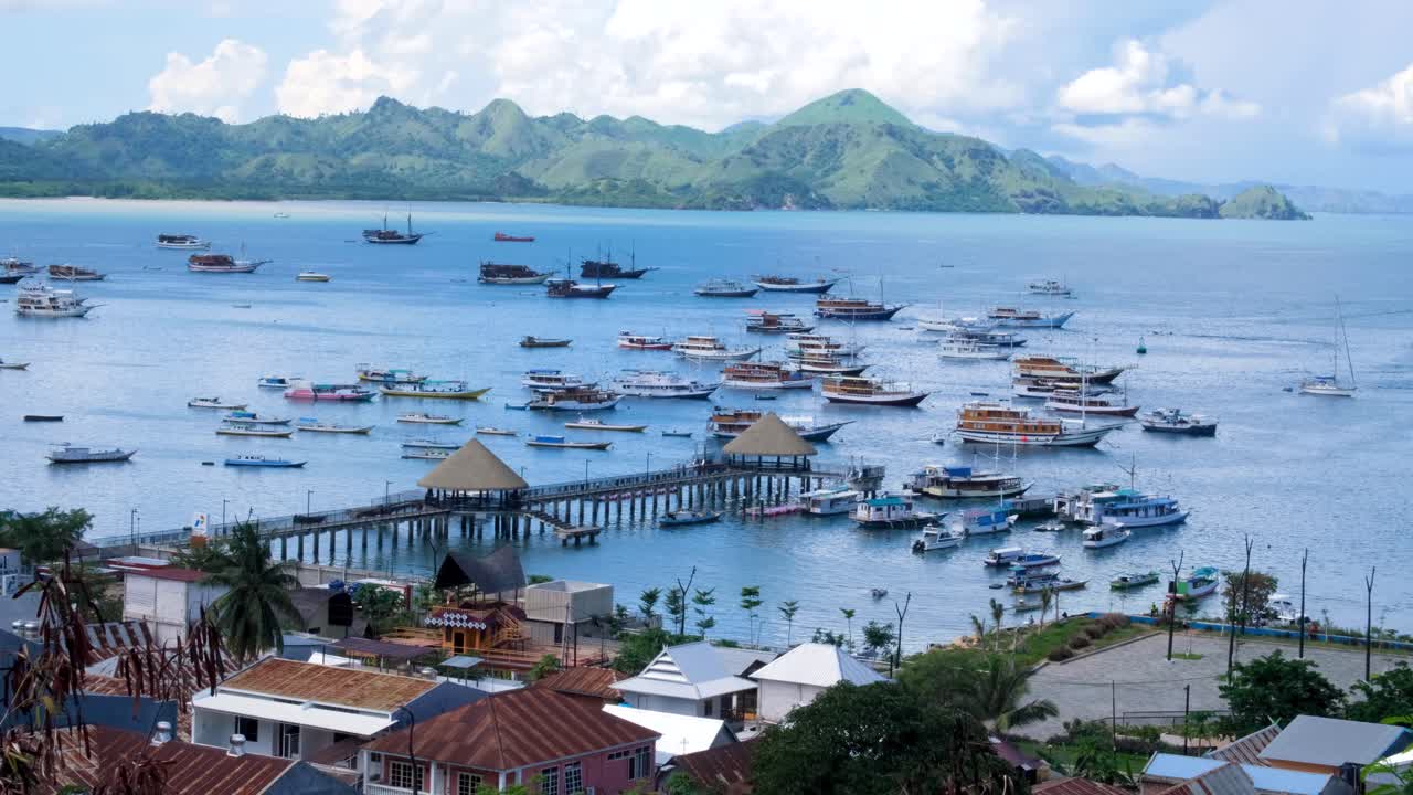 vista panorámica de labuan bajo marina y pesca atracada, vida a bordo y barcos turísticos con islas tropicales a lo lejos en la isla de flores, región de nusa tenggara en el este de indonesia
