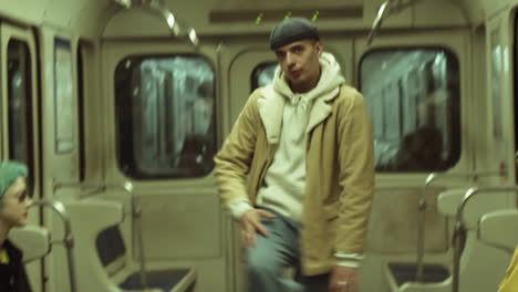 young man dancing hip hop with girls in metro train