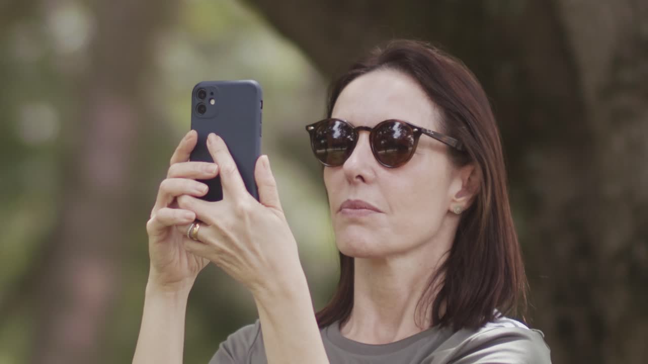 Modern technology, middle-aged female, nature background, slow-mo