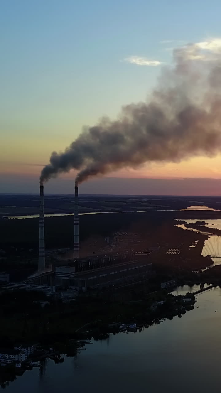 Factory Pipe Polluting Air. Factory pipe polluting air against sunset, environmental problems, smoke from chimneys Vertical video