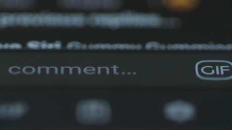 macro finger touching comment button on facebook on smartphone