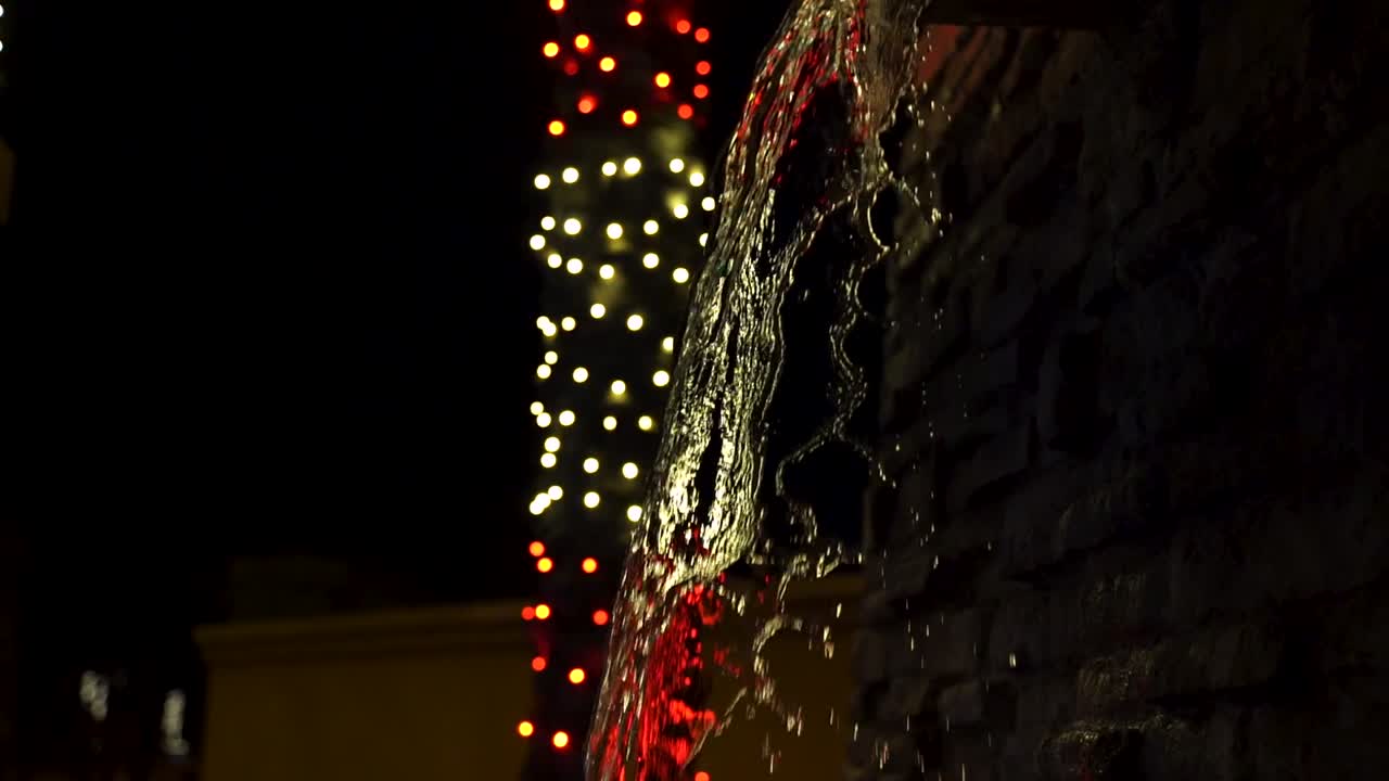 Waterfall Fountain being Backlit by Blurry Lights