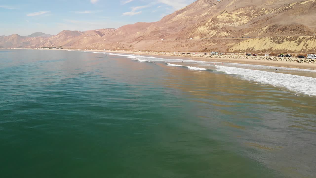 Ripresa aerea di surfisti in attesa di prendere un'onda nella California meridionale.