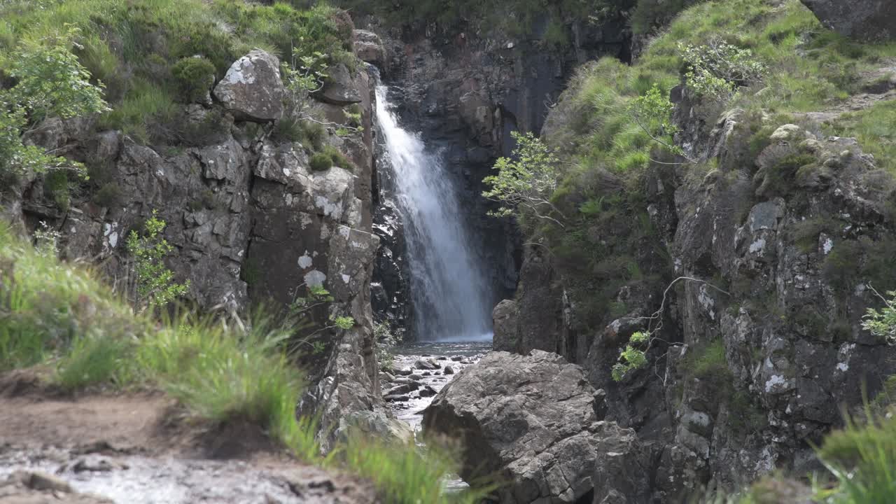cascada vista desde el sendero en las piscinas de hadas en la isla de skye