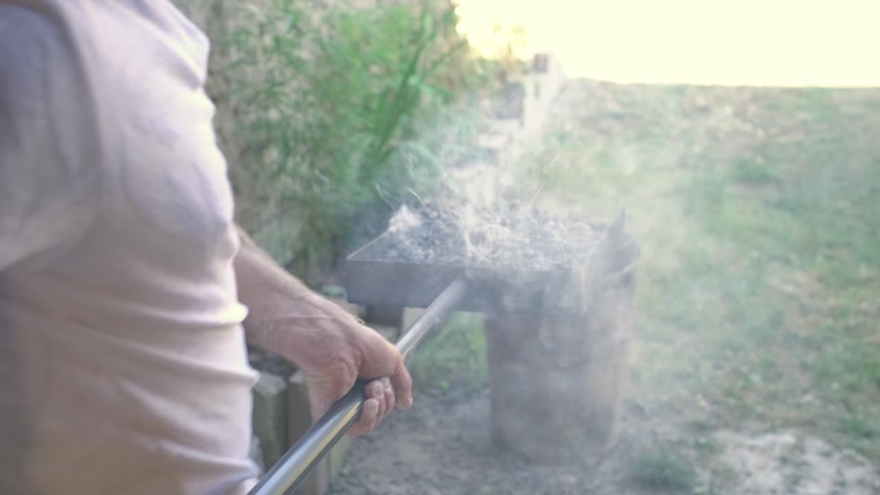 baker is take a big shovel, to take of the traditional stone oven, embers and fire, displacing it outside, in a big metal bucket