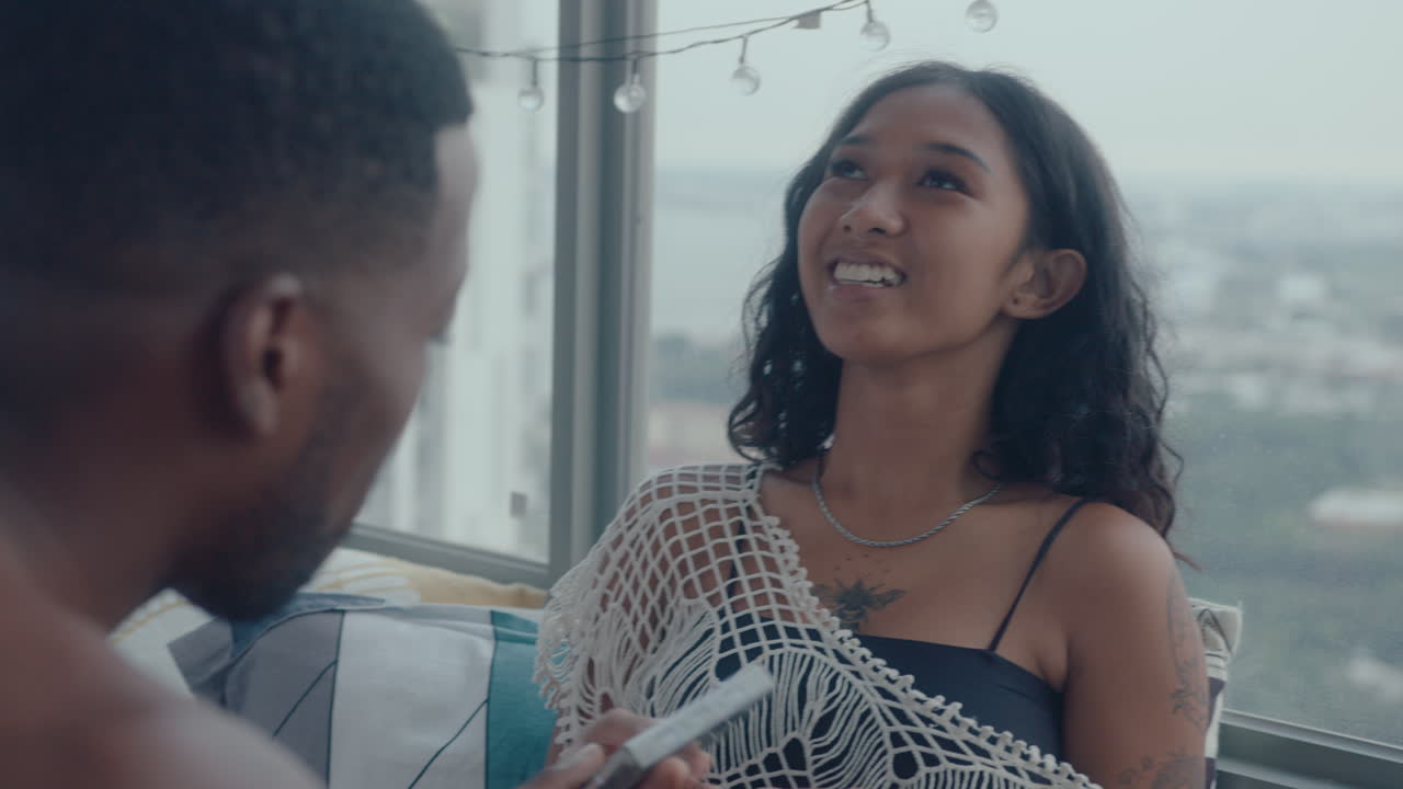 Young Woman Discussing Cassette Tape with Boyfriend at Home