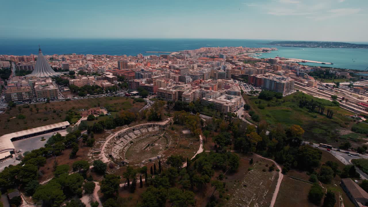 Siracusa archaeological site with stone amphitheater and old town in southern Sicily, Italy. Aerial