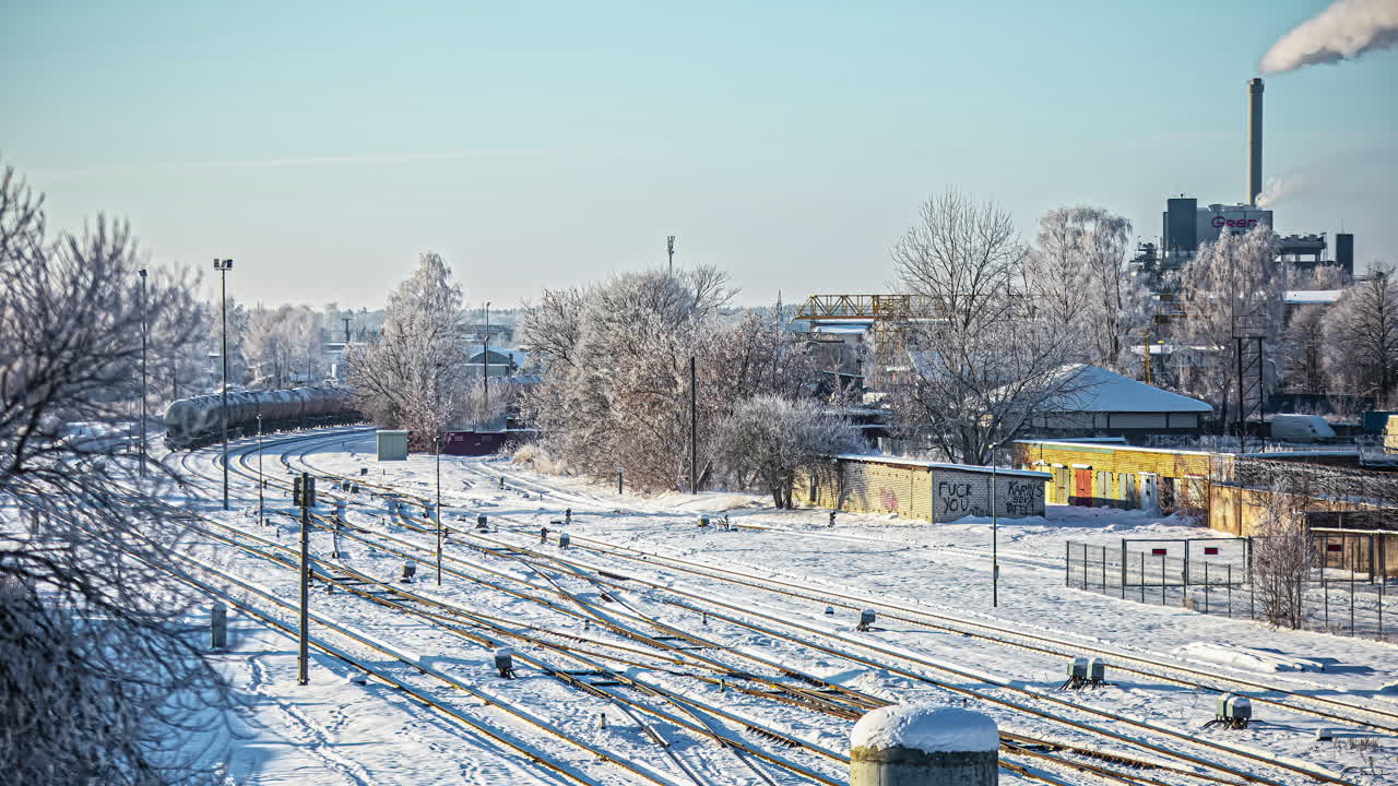 겨울에 굴뚝에서 증기가 방출되면서 유조선 열차가 공장을 지나갑니다 - 시간 경과