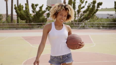 sporty young woman with a baseball on a court