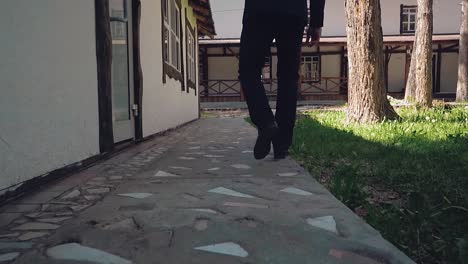 un joven camina por el camino a lo largo de la casa