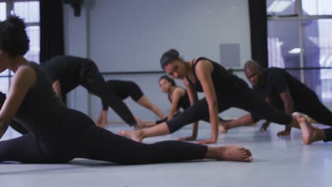 grupo multiétnico de bailarines modernos en forma masculinos y femeninos practicando una rutina de baile