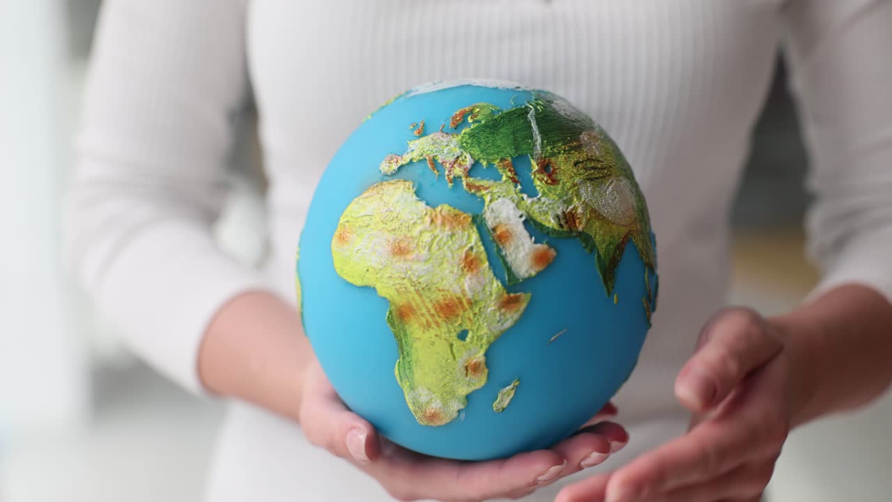 Hands cradling and protecting a globe, symbolizing environmental care
