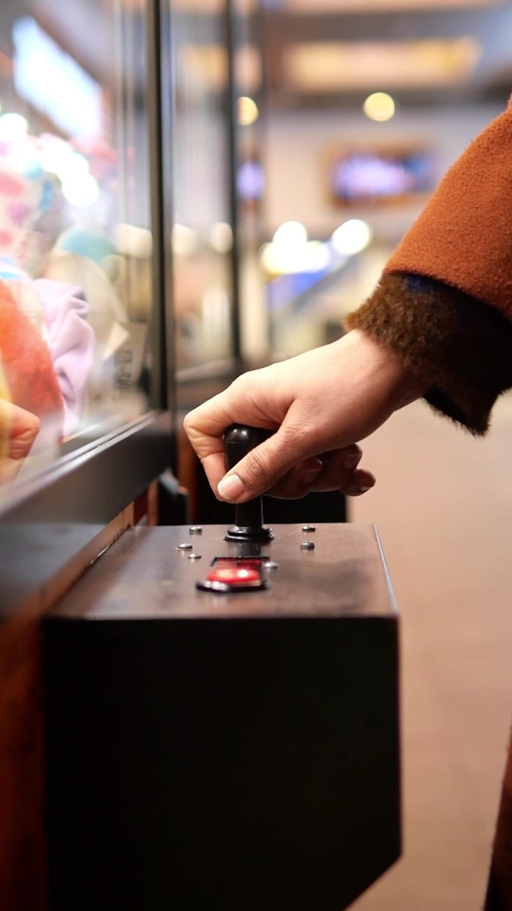 Mano di una persona che aziona il joystick di una macchina a gru