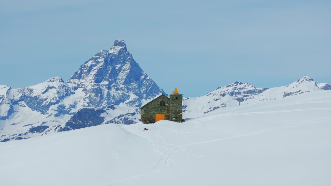 Santuario Clavalité with Matterhorn or Cervino in background, peak snowy Alps, Cheneil, Italy. Aerial drone at low altitude, lateral view, copy space