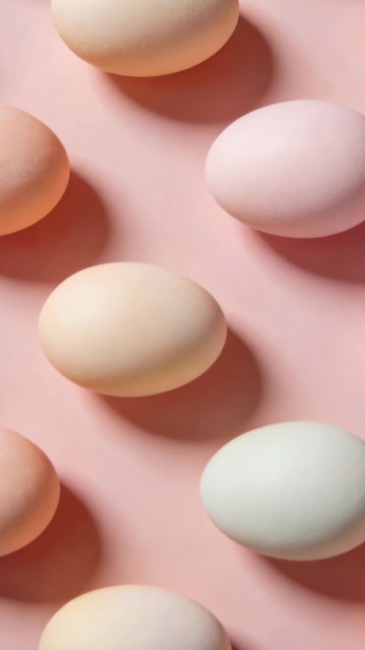 Camera sliding downward, pastel eggs remaining stationary while soft light shifting for design