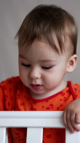 cute little kid playing in the bed. cheerful small child in pajama play. vertical video