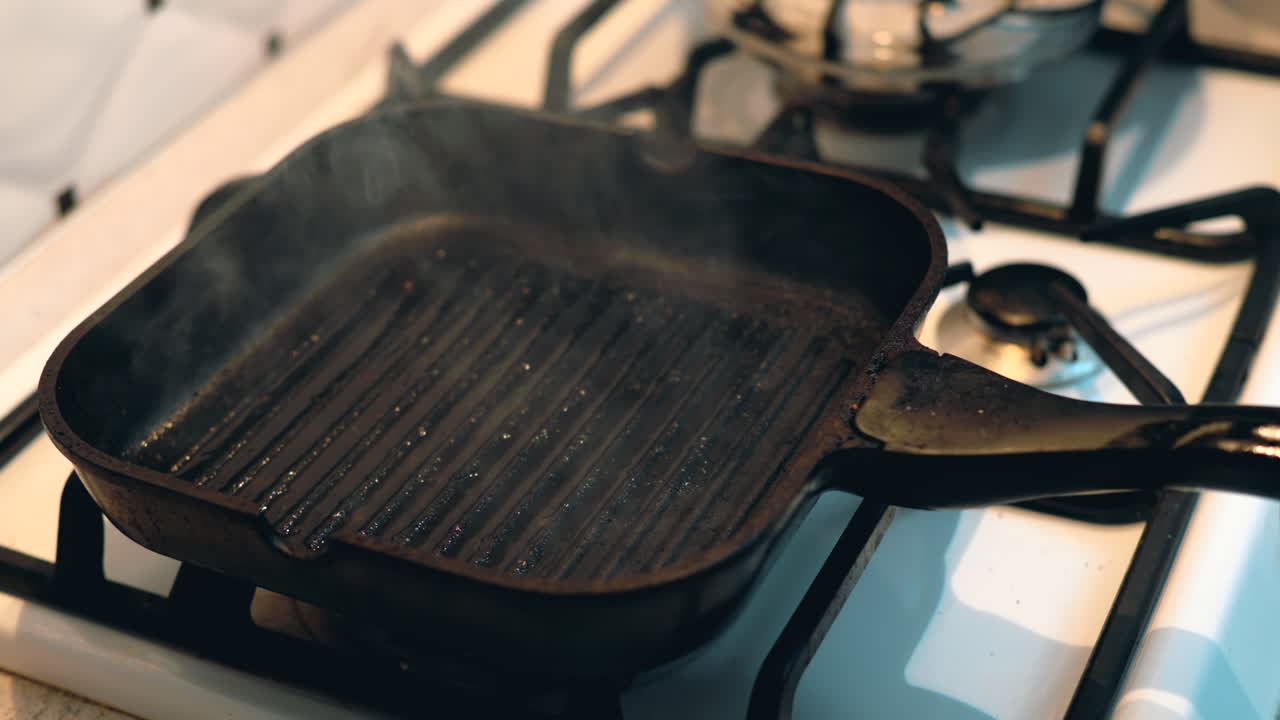 Woman cooking chicken breast on a grill pan