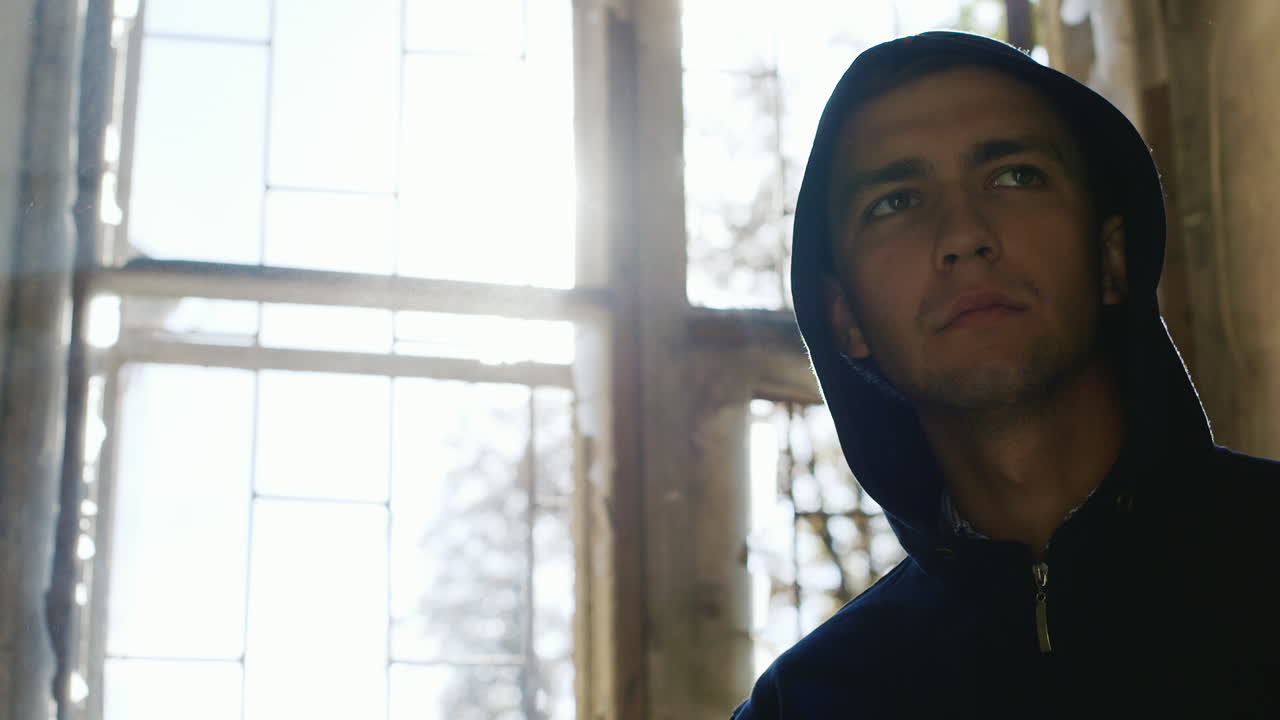 범죄자는 버려진 집 창문에서 담배를 피운다