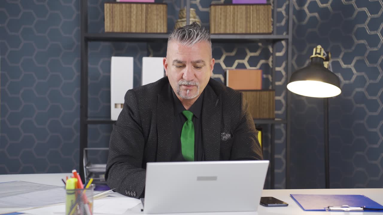 un hombre de negocios estresado usando una computadora portátil.