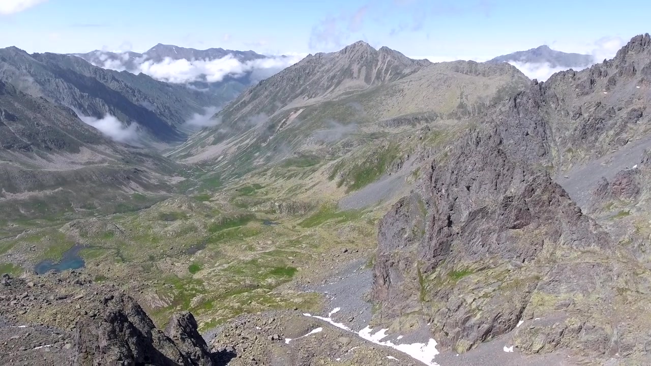 Luftaufnahme von schroffen Berggipfeln und einem Alpental