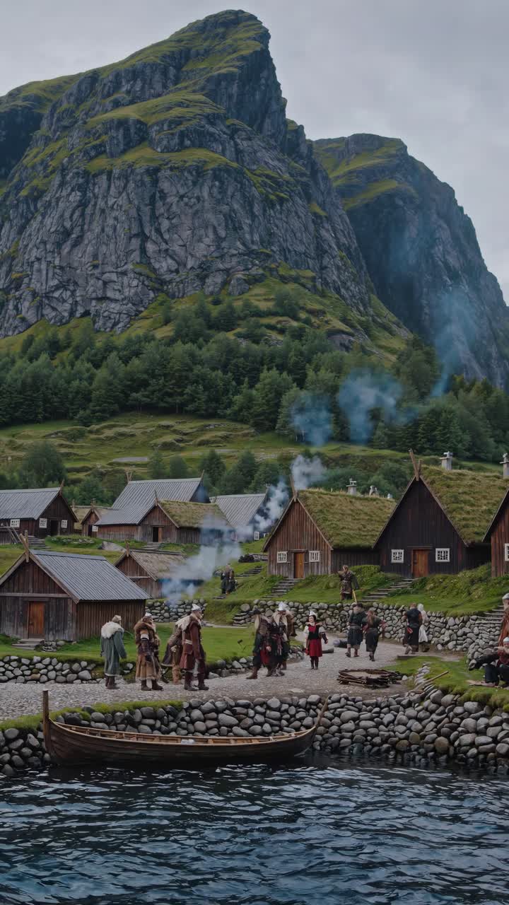 Aerial view of a medieval village by a lake, surrounded by mountains
