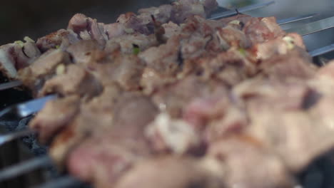 Raw-kebab-cooking-on-grill.-Raw-pork-shashlik.-Close-up.-Marinated-meat-grilling