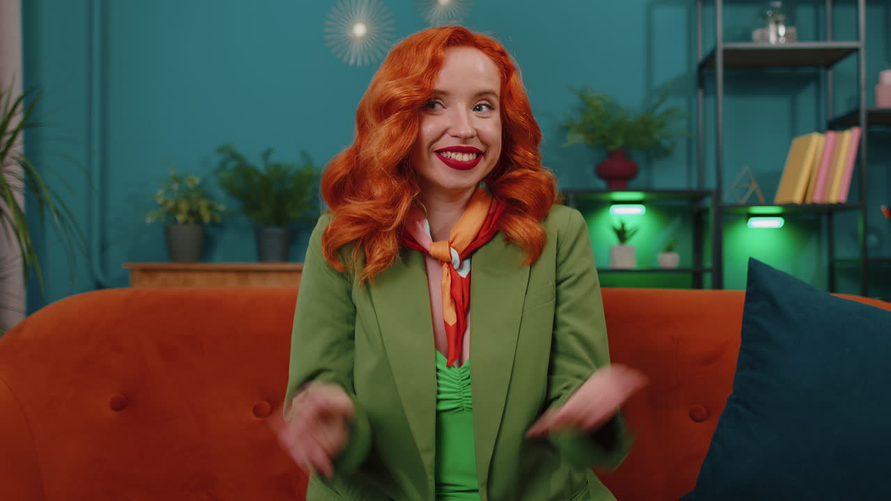 가정 의 소파 에 앉아 카메라 를 보고 친구 나 가족 과 비디오 컨퍼런스 통화 를 하는 여자