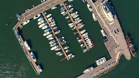 top view of drone flying above the marina with moored yachts, ships and motorboats at the sunny day in sopot, poland