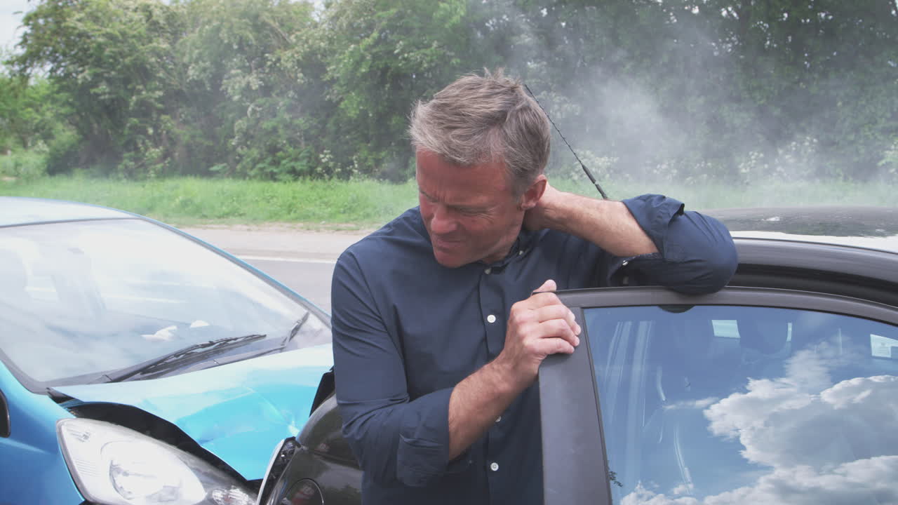 충돌 후 차에서 내리는 채찍질 부상을 입은 남성 운전자