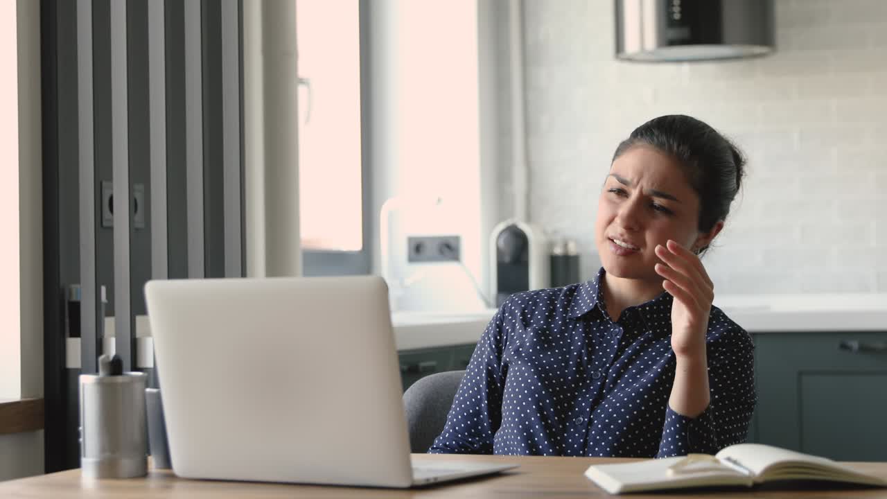 Indian woman working on laptop feels irritated due device problems
