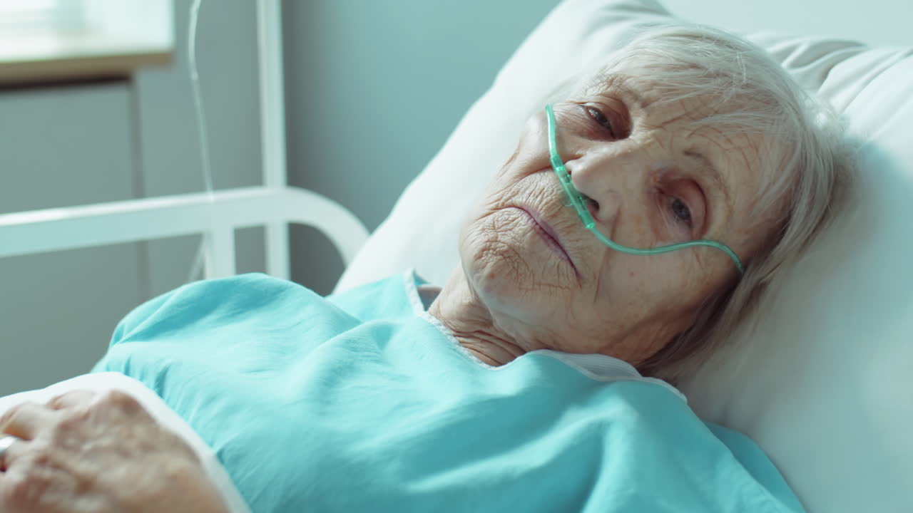 Ritratto di donna anziana con cannula nasale in ospedale.
