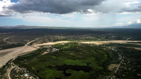 Drone-shot-of-the-central-lake-and-palm-plantations-inside-an-oasis-in-baja-california-sur-near-los-cabos-mexico-during-a-storm