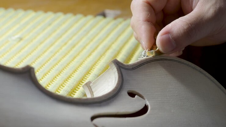 macro close up of artisan luthier maker work on new classic handmade raw violin smooth edge in waist and purfling rasp in workbench of workshop in Cremona Italy 4k video