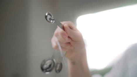 pouring salt into a mixing bowl from a measuring spoon