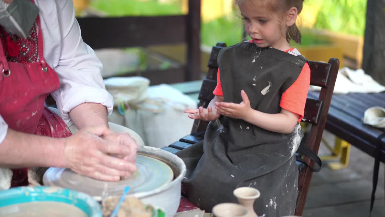 alfarero enseñando alfarería niña