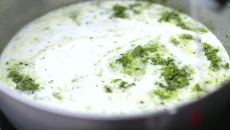 coconut milk poured into thai green curry paste