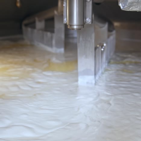 two big automatic nozzles turning and mixing the dairy product. fermented milk being mixed up in a big tank. butter and cheese manufacturing at modern plant